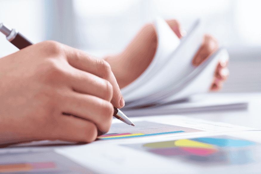 Person analysiert Finanzberichte mit bunten Diagrammen zur Einhaltung der GoBD und Aufbewahrungsfristen.