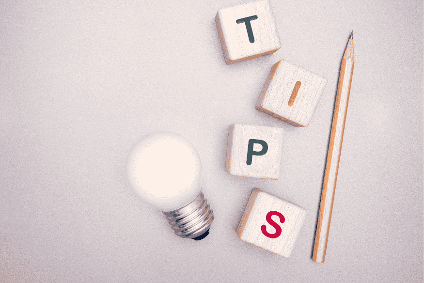 Kreative Darstellung mit Würfeln, die das Wort "TIPS" buchstabieren, neben einer Glühbirne und einem Bleistift – symbolisiert praktische Ratschläge zur Umsetzung der 7-Tage-Regel im Alltag.