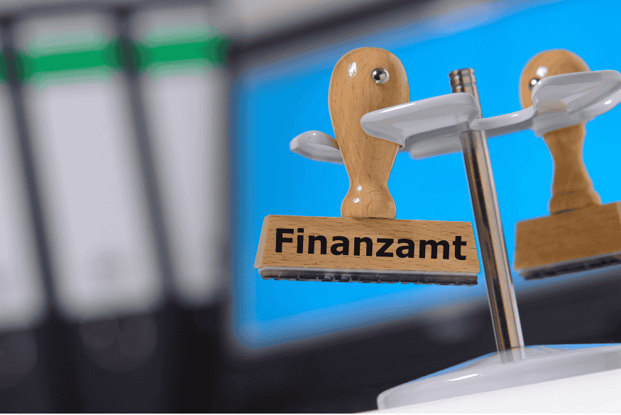 Stempel mit der Aufschrift Finanzamt vor Aktenordnern als Symbol für Lohnsteuer und Steuerklassen