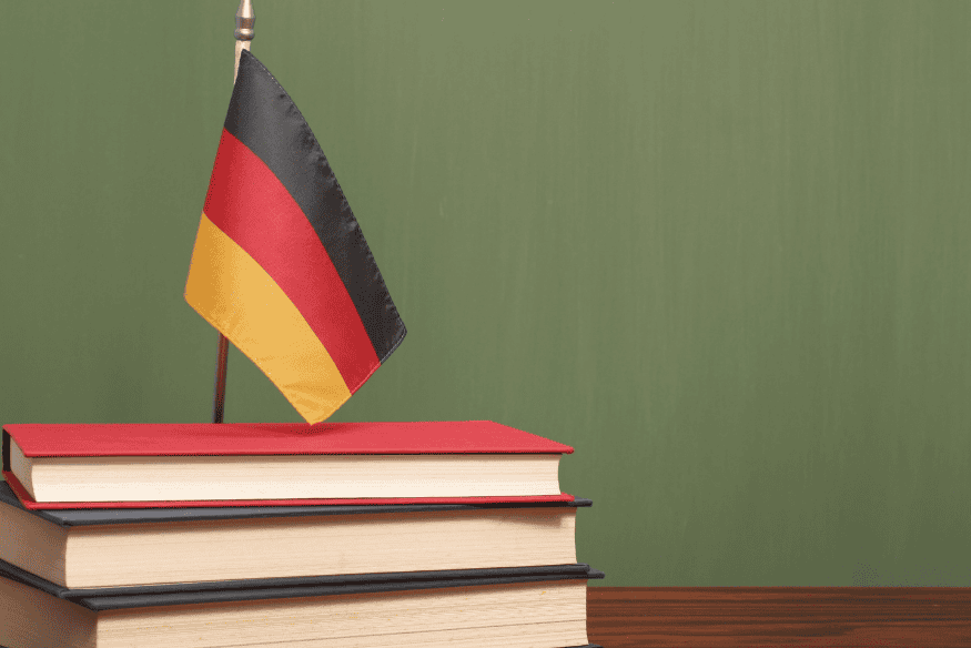 Stapel Bücher mit deutscher Flagge als Symbol für Studium in Deutschland und Studienfinanzierung