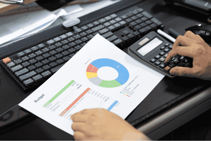 Student erstellt Budgetplan mit Diagramm und Taschenrechner, um Studium ohne Schulden zu finanzieren