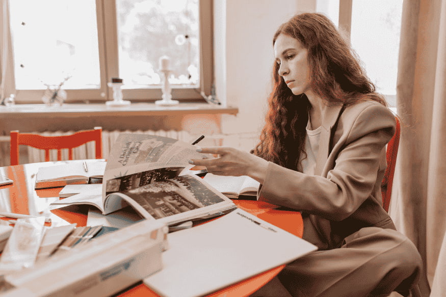 Studentin recherchiert Unterlagen und Fördermöglichkeiten, um Studium mit BAföG und Nebenjob zu finanzieren