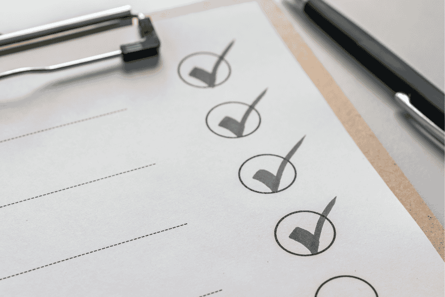 Nahaufnahme einer Checkliste mit Häkchen – symbolisiert die monatliche Überprüfung von Ausgaben zur Vermeidung unbewusster Kostenfallen im Alltag.