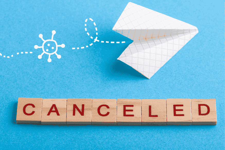 Symbolbild mit Papierflieger und Holzbuchstaben „CANCELED“ – steht für geplante Kündigungen von Abos, Konten und Karten im Rahmen des finanziellen Minimalismus.