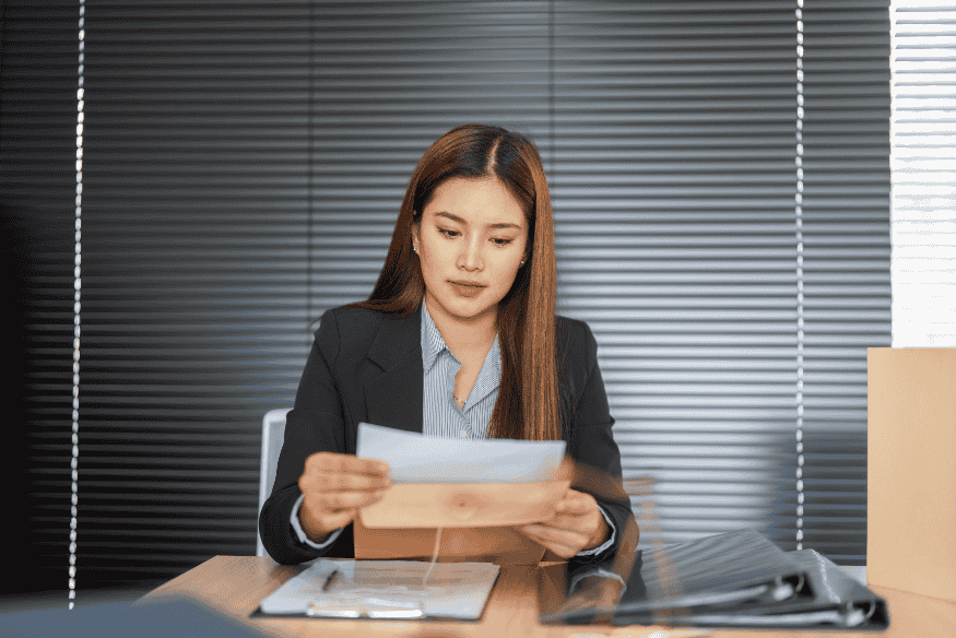 Geschäftsfrau im Büro liest Finanzunterlagen zu Aufbewahrungsfristen und GoBD-Vorschriften.