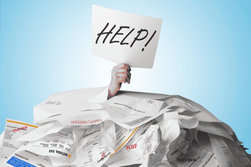 Hand mit einem „HELP!“-Schild ragt aus einem Stapel unbezahlter Rechnungen hervor und symbolisiert finanzielle Überforderung.