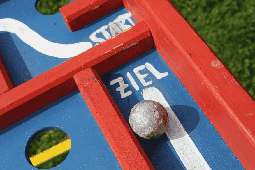 Holzlabyrinth mit Kugel zwischen Start und Ziel als Metapher für den Weg zur erfolgreichen Gehaltsverhandlung