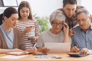 Mehrgenerationenfamilie bespricht Finanzen am Tisch und plant gemeinsame Ausgaben