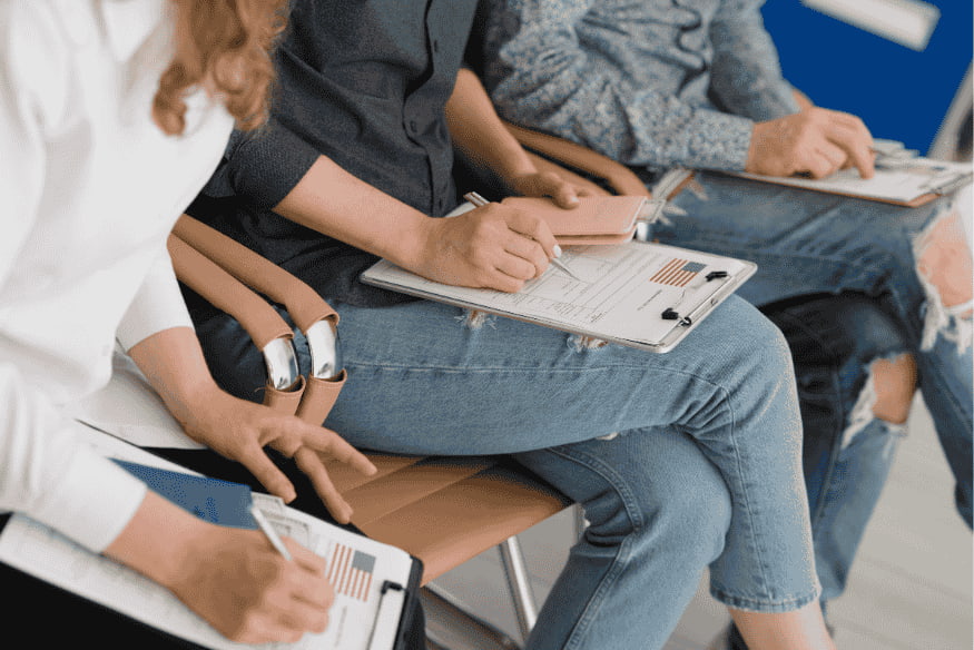 Menschen füllen Formulare auf Klemmbrettern aus – Anmeldung und Behördenwege für Expats in Deutschland