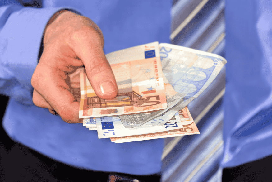 Mann hält Euro-Scheine in der Hand, um Mietkaution und Umzugskosten zu bezahlen